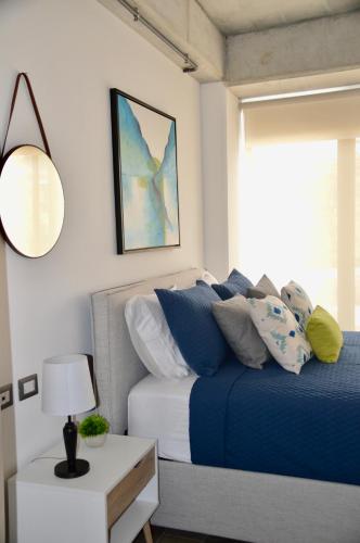 a bedroom with a blue bed and a window at Cozy Stays Cayala Apartments 4 in Guatemala