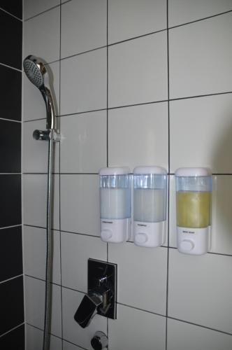 a bathroom with three cups on a wall at Cozy Stays Cayala Apartments 4 in Guatemala