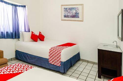 a small room with a bed and a sink at OYO Hotel Cabo Del Sur, Cabo San Lucas in Cabo San Lucas