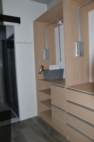 a bathroom with a wooden cabinet with a sink at Cozy Stays Cayala Apartments 4 in Guatemala