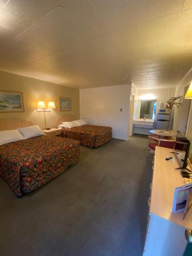 Habitación de hotel con 2 camas y escritorio en Birchwood inn, en Chincoteague