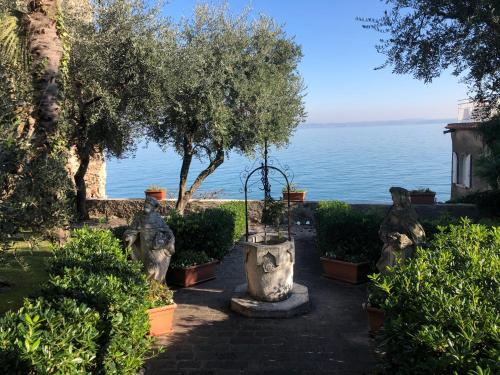a garden with a view of the water at Hotel Alfieri in Sirmione