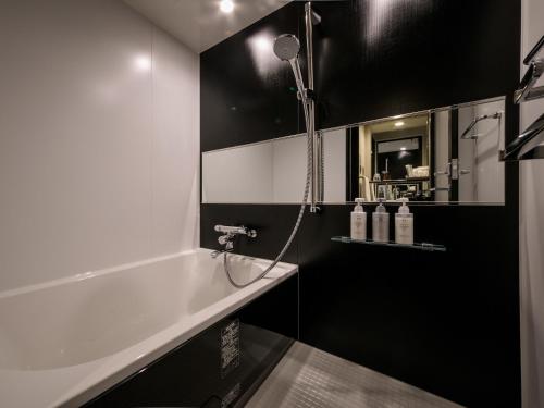 a bathroom with a shower and a bath tub at S-peria Hotel Kyoto in Kyoto