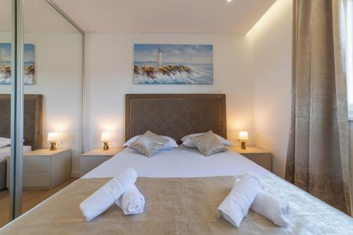 um quarto com uma cama com duas almofadas brancas em Apartman Blue Wave em Trogir