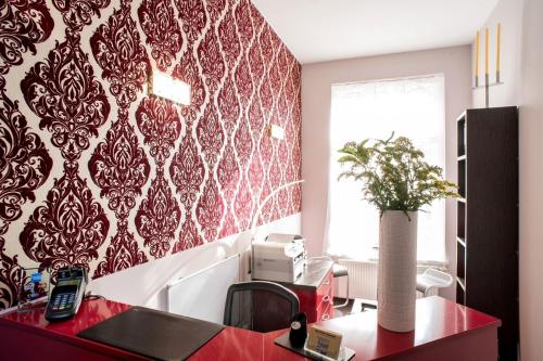 a kitchen with a red and white patterned wall at Hotel Residenz Begaswinkel in Berlin