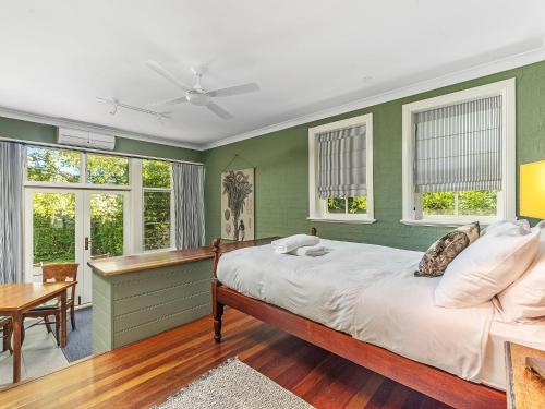 a bedroom with green walls and a bed and a table at Milhouse Berry in Berry