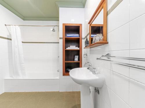 a white bathroom with a sink and a shower at Milhouse Berry in Berry