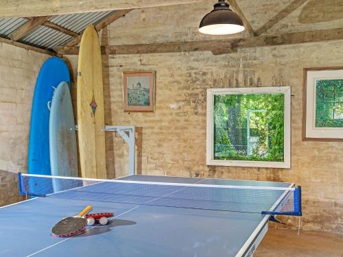 a ping pong table in a room with surfboards at Milhouse Berry in Berry