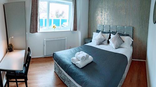 1 dormitorio con 1 cama con toallas en Brookside 2BR Flat Oxford City Centre Free Parking en Oxford