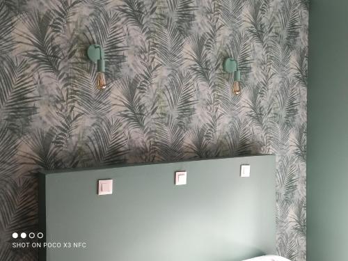 a room with a wall with a palm tree wallpaper at Au bord de l'eau in Joux