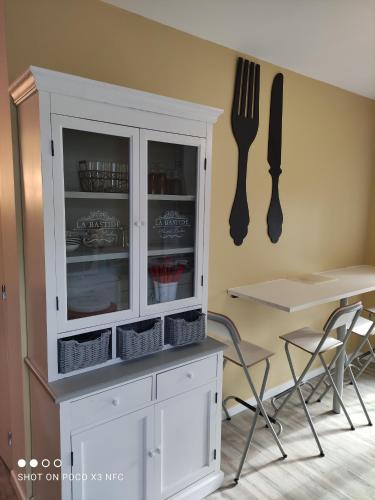 a kitchen with a white cabinet and a fork and knife at Au bord de l'eau in Joux