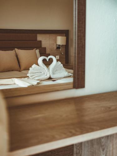 two swans are towels on a bed in front of a mirror at Studio Lia in Skala Marion