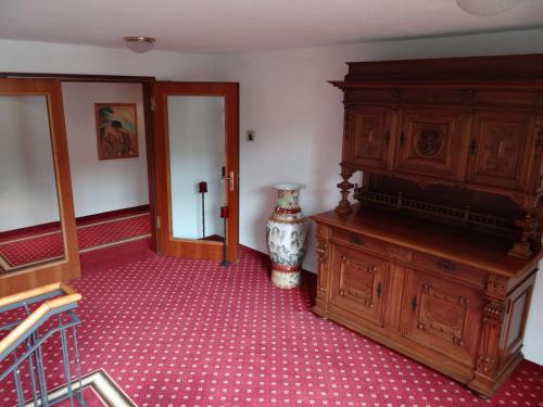 a room with a large wooden cabinet and a vase at Hotel-Restaurant Bibermühle GmbH in Tengen