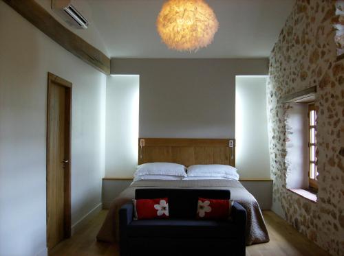 1 dormitorio con 1 cama con sofá y lámpara de araña en Maison Anderetea, en Mendionde