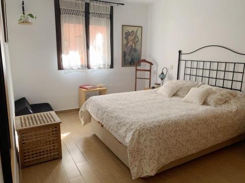 a bedroom with a large bed and two windows at Gran piso en el centro de Alcalá in Alcalá de Henares