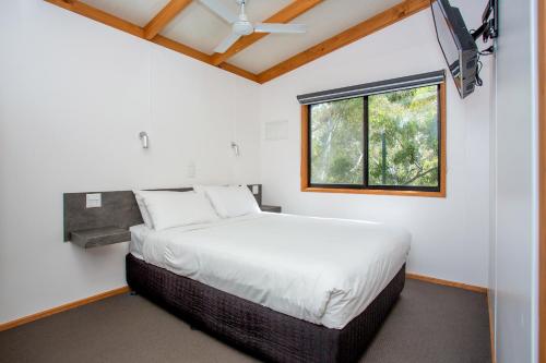 un dormitorio con una cama y una ventana en BIG4 Melbourne Holiday Park, en Melbourne