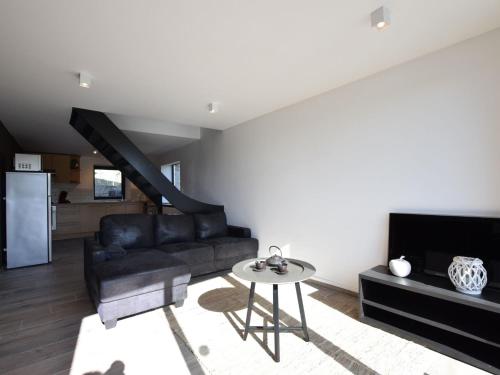 a living room with a couch and a table at Charming Holiday Home in Sainte Ode with Terrace in Amberloup