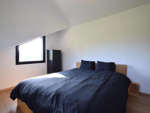 a bedroom with a bed with blue sheets and a window at Charming Holiday Home in Sainte Ode with Terrace in Amberloup