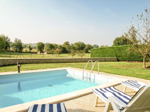 una piscina con 2 sillas de césped en Superb holiday home with pool en Cressensac