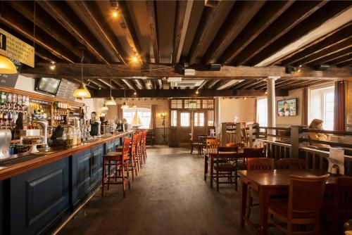 a restaurant with a bar and tables and chairs at The Old Custom House in Padstow
