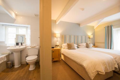 a bedroom with a bed and a sink and a toilet at The Old Custom House in Padstow