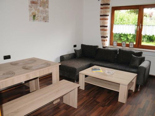 ein Wohnzimmer mit einem Sofa und 2 Tischen in der Unterkunft Apartment in the Bavarian Forest with balcony in Drachselsried