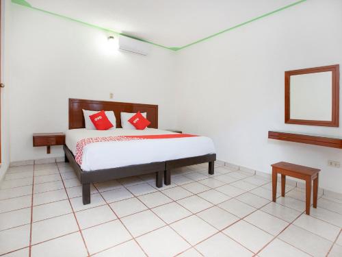 a bedroom with a bed with red pillows on it at OYO Hotel Nachancan in Chetumal
