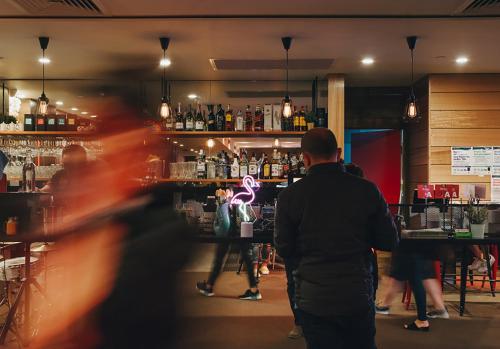 a group of people standing at a bar at Causeway 353 Hotel in Melbourne