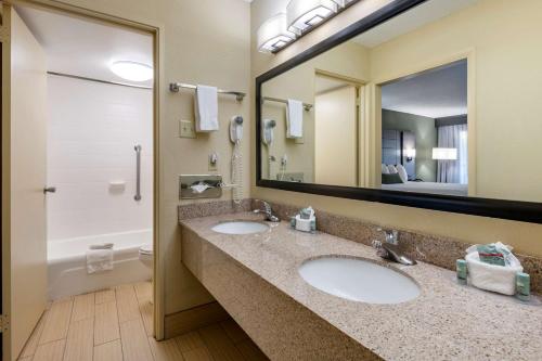 a bathroom with two sinks and a large mirror at Best Western Downtown Stuart in Stuart