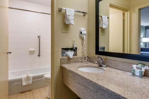a bathroom with a sink and a mirror and a toilet at Best Western Downtown Stuart in Stuart