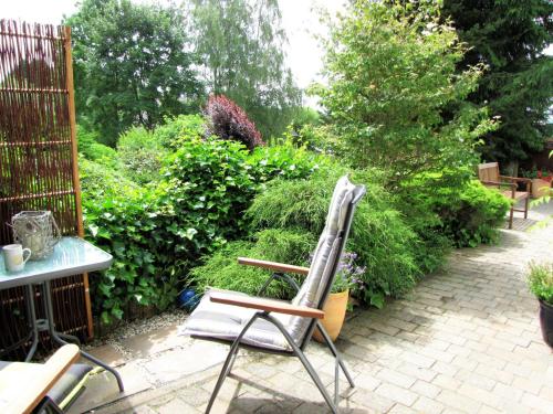 a chair sitting on a patio in a garden at Spacious apartment in the Vulkaneifel in Ulmen