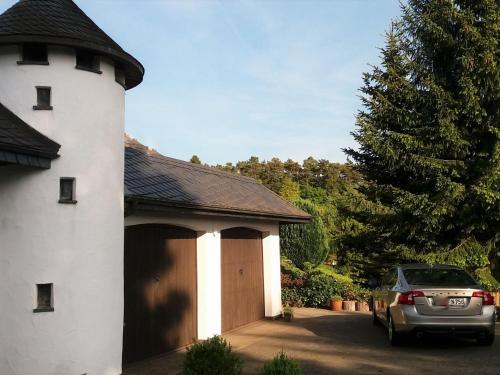 a car parked in front of a house with a garage at Spacious apartment in the Vulkaneifel in Ulmen