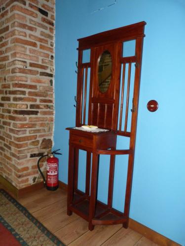 a wooden dressing table with a mirror and a fire extinguisher at Hotel Rural Los Texos in La Riera