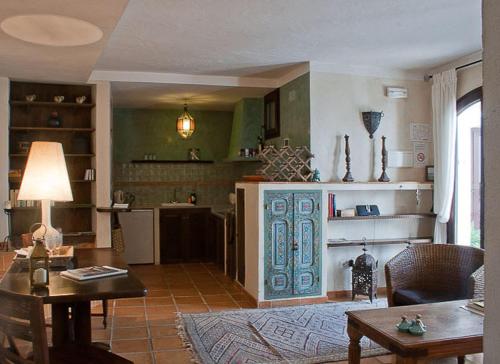 a living room with a table and a kitchen at Darcilla Guest House in Tarifa