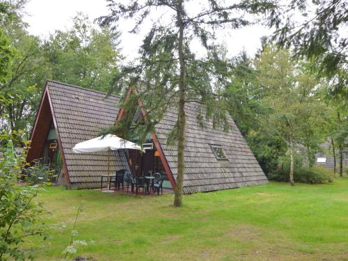 StramproyにあるLovely Holiday Home in Limburg amid Lush Forestのテーブルと椅子が前にある家
