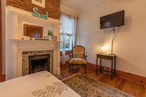 a living room with a fireplace and a tv at Surf Song Bed & Breakfast in Tybee Island