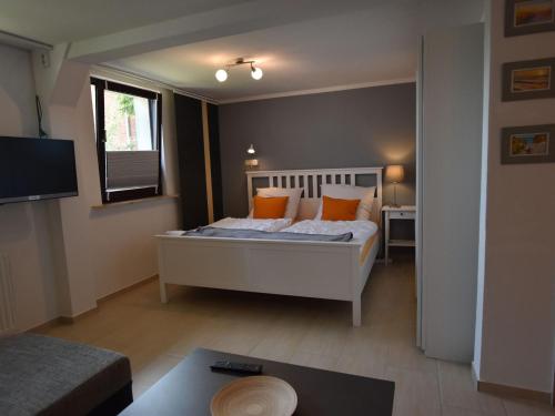 BlowatzにあるApartment in Robertsdorf with Garden, Terrace, Barbecueのベッドルーム1室(オレンジ色の枕が付いたベッド1台付)