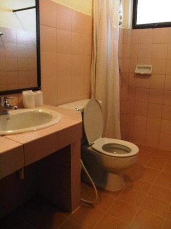 a bathroom with a toilet and a sink and a mirror at Baan Klang Aow Beach Resort in Ban Krut