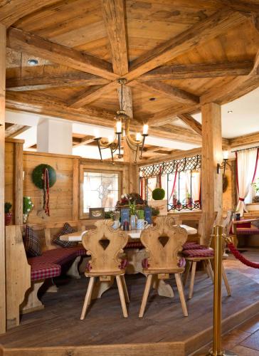a dining room with wooden ceilings and a table and chairs at Ortner's Resort in Bad Füssing