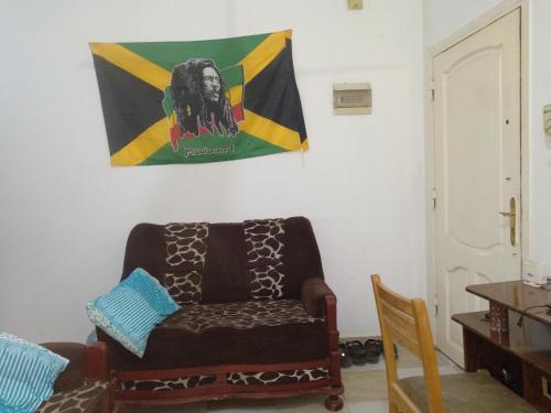 a living room with a couch and a flag on the wall at Bob Marley Homestay in Hurghada