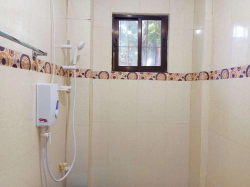 uma casa de banho com um chuveiro e uma janela em RedDoorz @ Garcia Hernandez Bohol em Garcia Hernandez