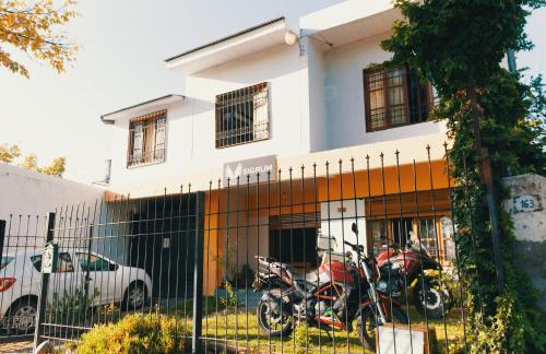 dos motocicletas estacionadas frente a una casa en SIGRUM Hostel en San Rafael