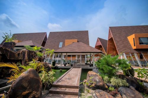a house with a wooden walkway in front of it at One of A Kind Resort @Trikora Beach - Bintan in Telukdalam