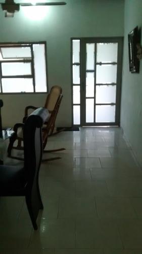 a room with two chairs and a door with windows at Hotel El Puerto in Tolú