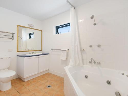 a bathroom with a tub and a toilet and a sink at Calypso Plaza Resort Unit 417 in Gold Coast