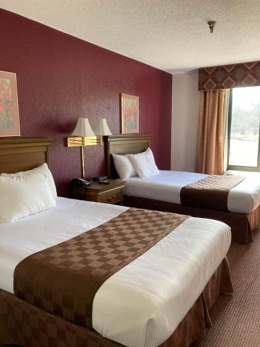 a hotel room with two beds and a window at Americourt Hotel - Mountain City in Mountain City