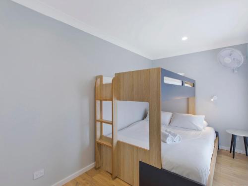 a bedroom with a bunk bed with a ladder at Beach House on Wyuna in The Entrance