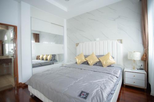 a white bedroom with a large bed and a mirror at KW pool villa pattaya in Pattaya Central