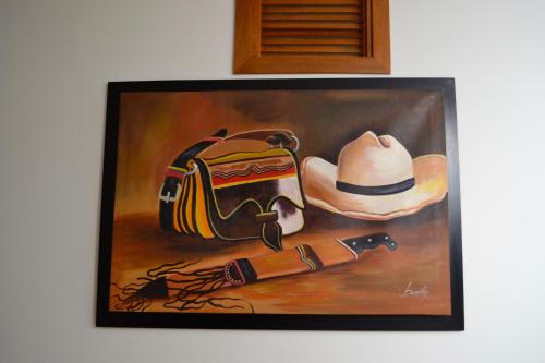 a painting of a cowboy hat and a gun at Hotel San Fernandos Plaza in San Rafael