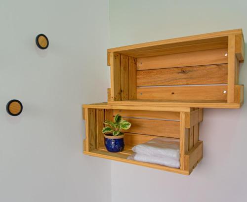a wooden shelf on a wall with a potted plant at MADÁ hostel in Sao Paulo